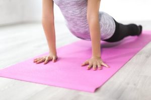 Woman doing cobra pose on yoga mat